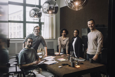 Portrait of smiling male and female entrepreneurs together in meeting room