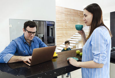 Portrait of man using laptop while sitting on table