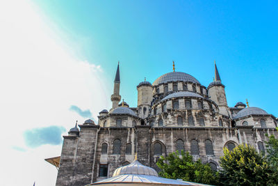 Low angle view of new mosque against blue sky