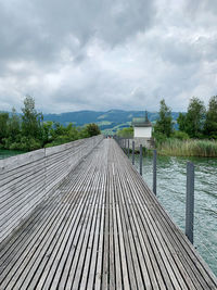 Surface level of boardwalk on pier against sky