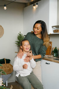 Happy family mother and child daughter taste christmas cookies in the kitchen in the house person