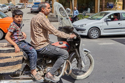 People sitting on street in city