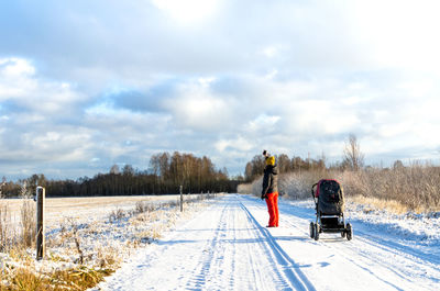 Rear view of people on snow covered field