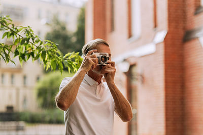 Man photographing against building