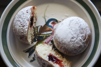 High angle view of fresh donuts with preserves served in plate