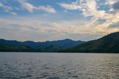 Scenic view of lake by mountains against sky