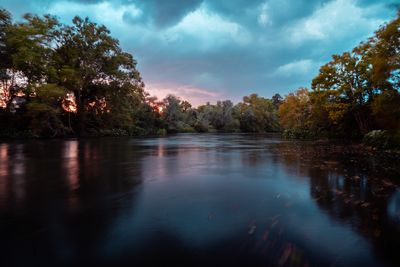 Scenic view of lake in forest against sky