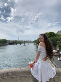 Woman standing in water against sky