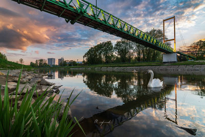 Bridge over lake against sky during sunset