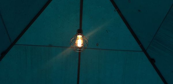 Low angle view of illuminated light bulbs hanging from ceiling