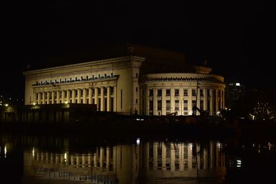 Reflection of building in lake at night