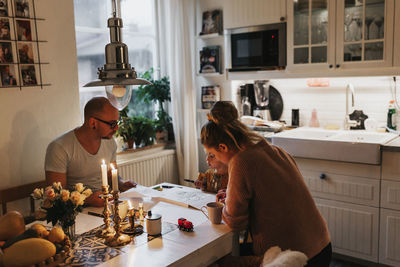 People sitting by table at home