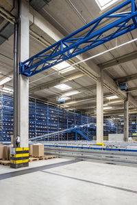 Cardboard boxes by conveyor belt in warehouse