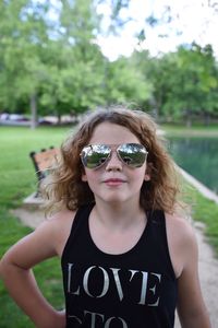 Portrait of girl wearing sunglasses while standing on field