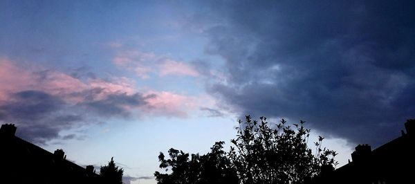 Low angle view of silhouette tree against cloudy sky