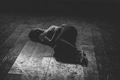 Full length of sad woman lying down on floor