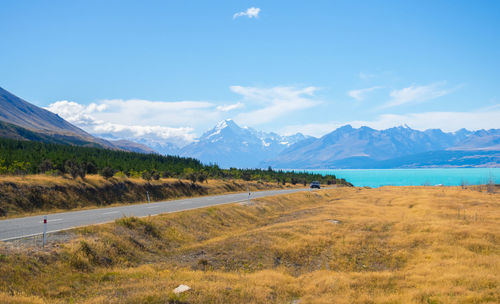 Scenic view of road by mountains against sky