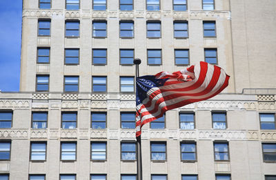 Low angle view of flag against building in city