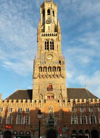 Low angle view of medieval belfry in market square in bruges. 