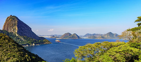 Scenic view of bay against blue sky