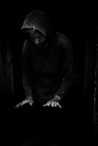 Man sitting against black background