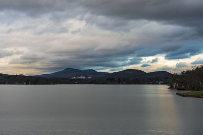 Scenic view of lake by mountains against sky