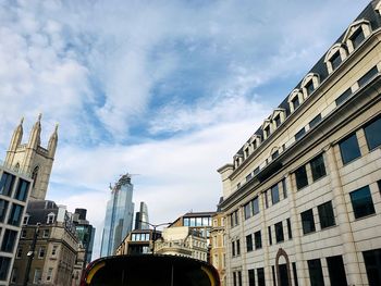 Low angle view of buildings against cloudy sky