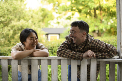 Side view of man sitting on bench at park