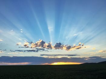 Scenic view of field against sky at sunset