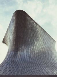 Low angle view of modern building against cloudy sky