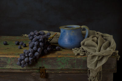 Close-up of grapes on table against wall