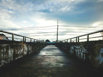 Empty footbridge against sky