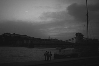 Cityscape against cloudy sky at sunset