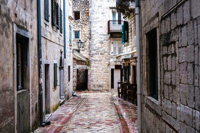 Narrow alley amidst old buildings in city