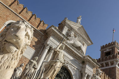 Low angle view of statue of historic building against sky