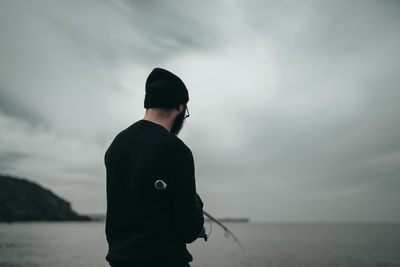 Man standing by sea against sky