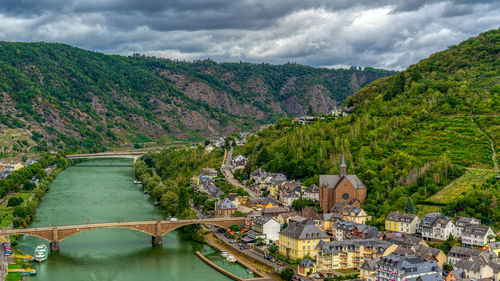 Bridge over river in city against sky