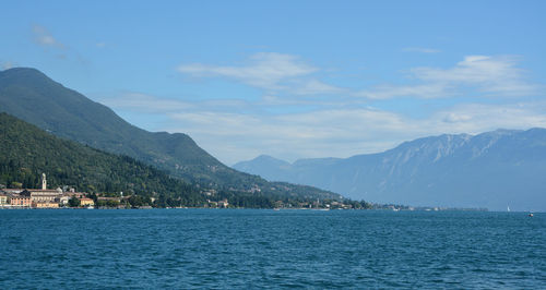 Scenic view of sea by mountains against sky