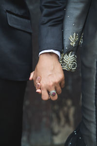 Midsection of couple holding hands