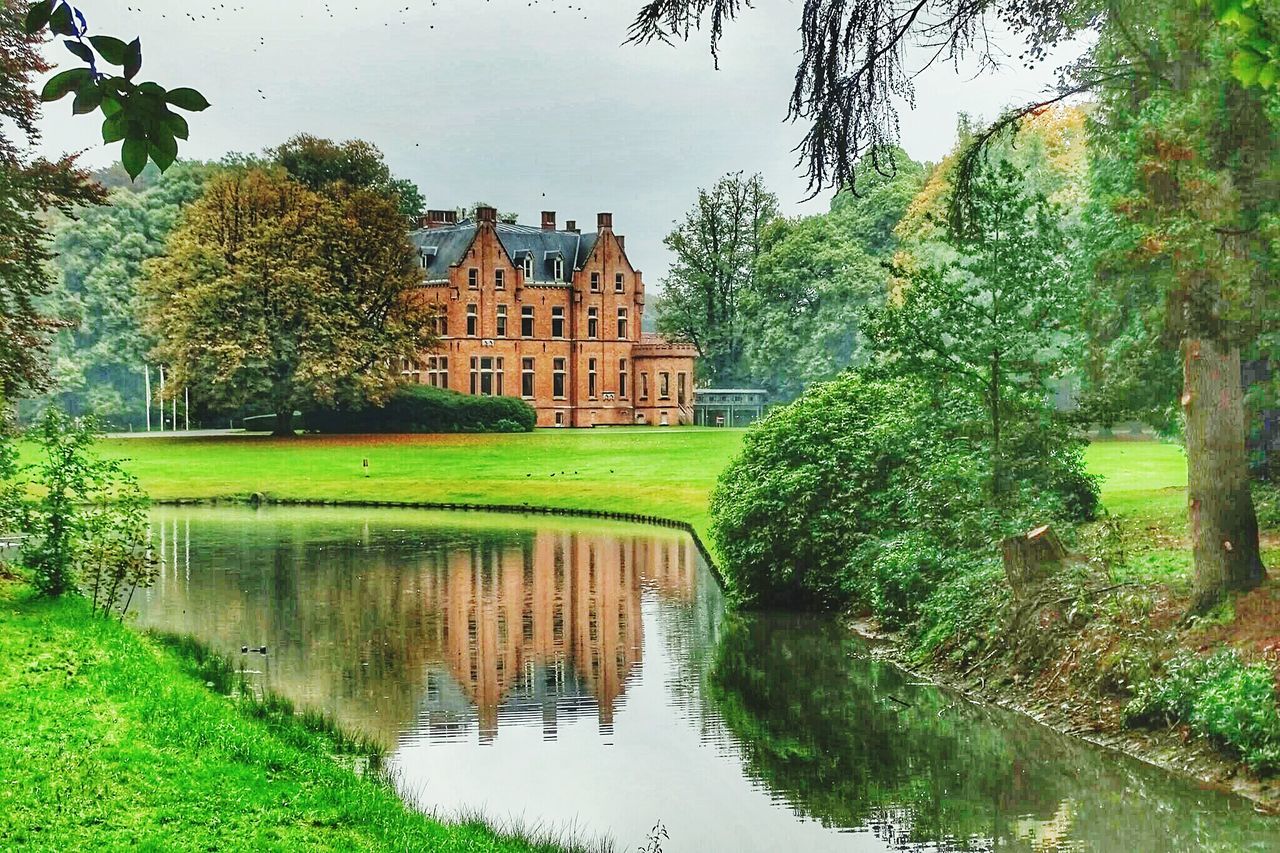 architecture, building exterior, water, built structure, tree, reflection, pond, green color, waterfront, canal, grass, growth, house, lake, sky, plant, day, nature, incidental people, river