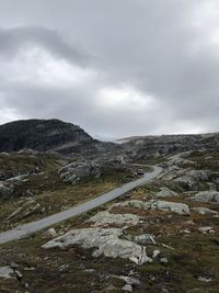 Road leading towards mountain against sky