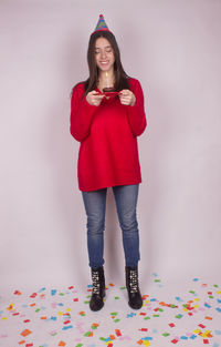 Portrait of woman standing against red background