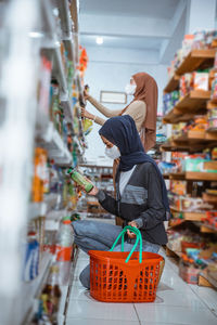 Side view of woman standing in supermarket