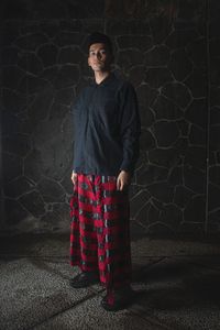 Man in red woven ethnic trousers and black shirt.