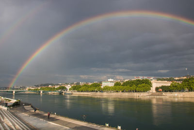 Rainbow over river against sky