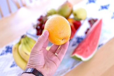 Cropped hand holding orange fruit