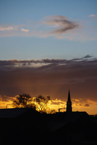 Silhouette of building against sky at sunset