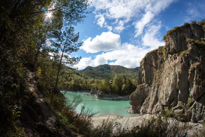 Scenic view of river by trees against sky