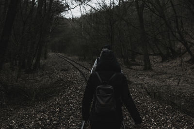 Rear view of man walking in forest