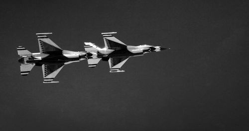 Low angle view of airplanes flying against sky